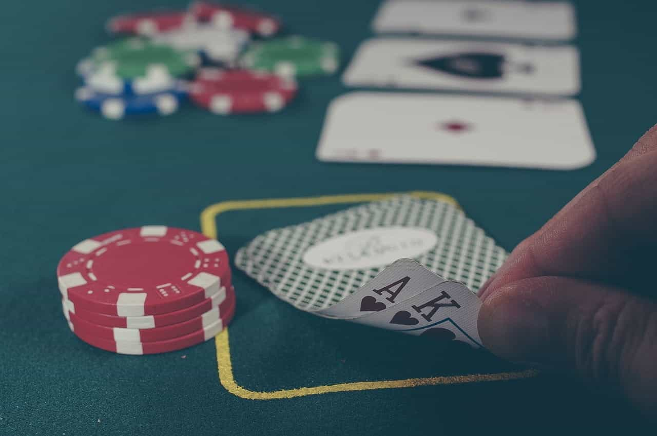 A poker table with two-hole cards and a stack of chips in the foreground.