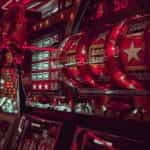 A close-up view of a row of slot machines, glowing red neon lights.