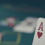 Ace-king of hearts in front of a poker table with chips on.