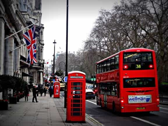 A red telephone box and a bus on a London street.