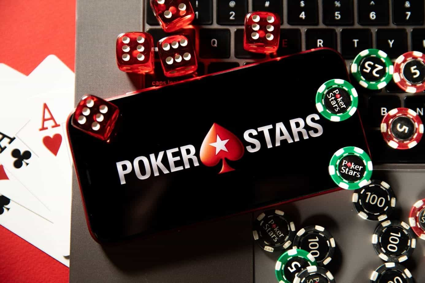 An iPhone displays PokerStars logo with chips and cards placed alongside it.