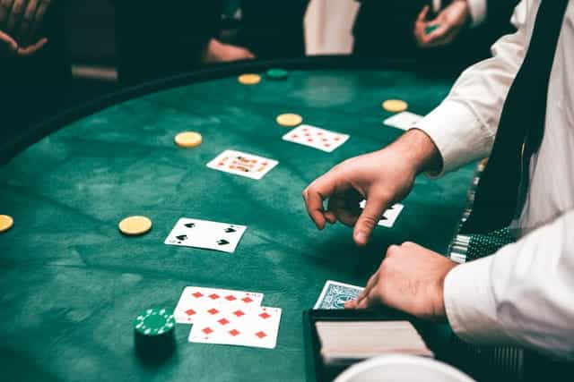 A croupier dealing cards in a game of poker at a casino.