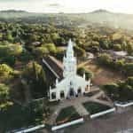 A church building surrounded by green trees in Paraguay.