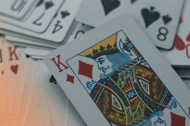 A king of diamonds placed on top of a deck of out of focus cards.