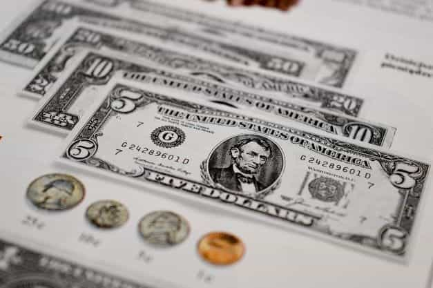 USA paper currency placed alongside coins.