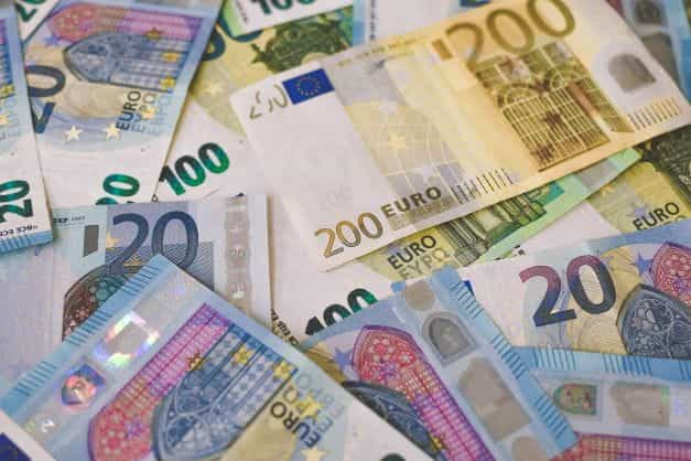 Euro notes of various denominations scattered on a flat surface.