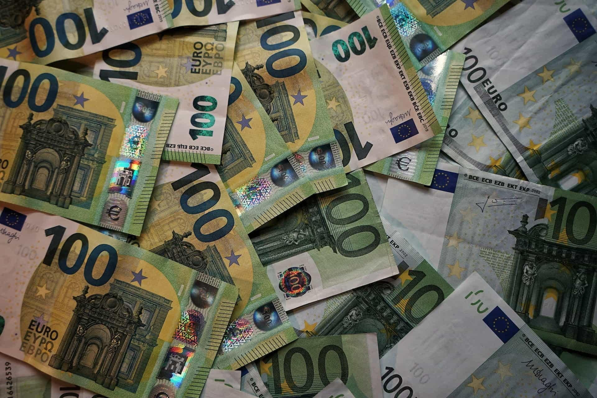 Several 100 euro bills scattered on a desk.