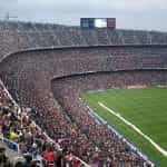 A huge sports stadium filled to the brim with spectators watching a large-scale sporting event.