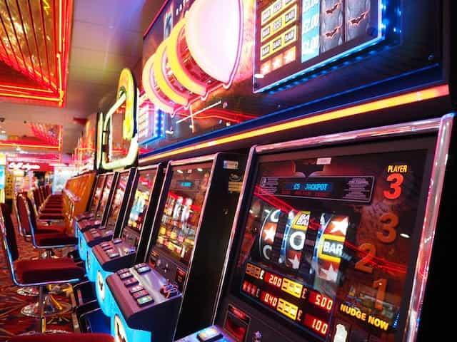 Slot machines in a gaming room, lit up in red light.