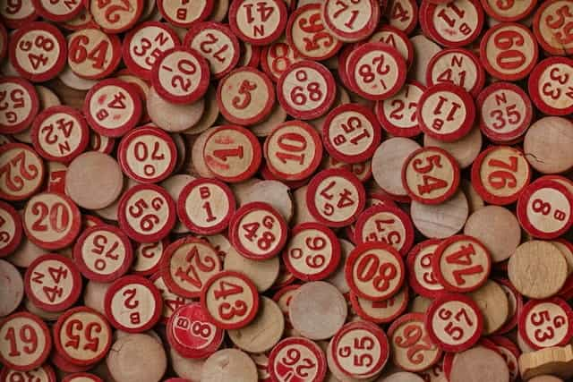 Painted red wooden bingo tiles spread across a flat surface.