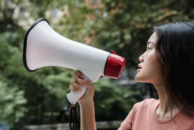 A woman speaking into a megaphone.