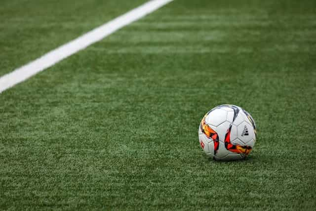 A football on a grass pitch.