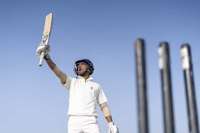 Cricket player holding up his bat