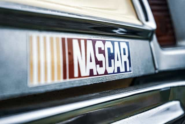 The world-famous NASCAR logo emblazoned on a bumper sticker placed on the back of a car.