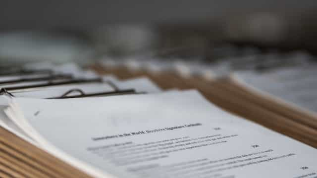 A stack of clipboards with printed documents on them.